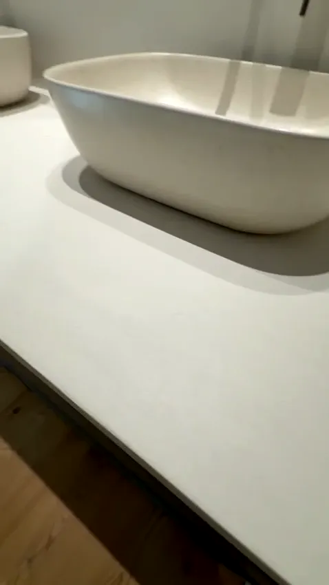 Baño con encimera de microcemento, dos lavabos y espejos ovalados